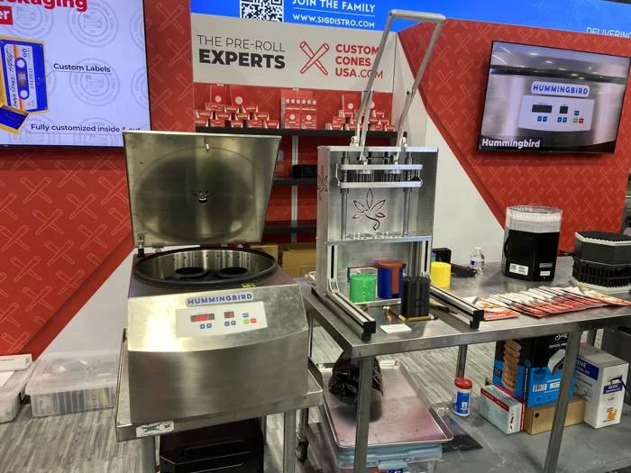 Hummingbird preroll manufacturing equipment displayed with Custom Cones USA at 2025 MJ Bizcon.