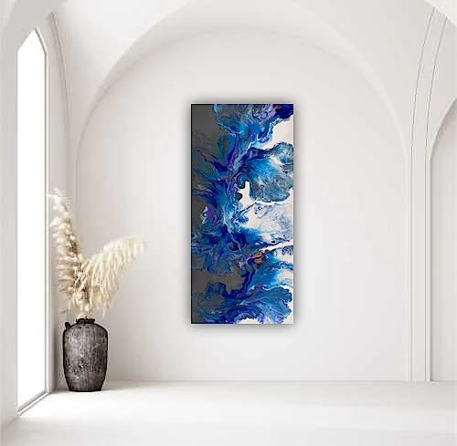 Abstract blue and white painting hanging on a white wall in a minimalist room with a black vase and dried pampas grass.