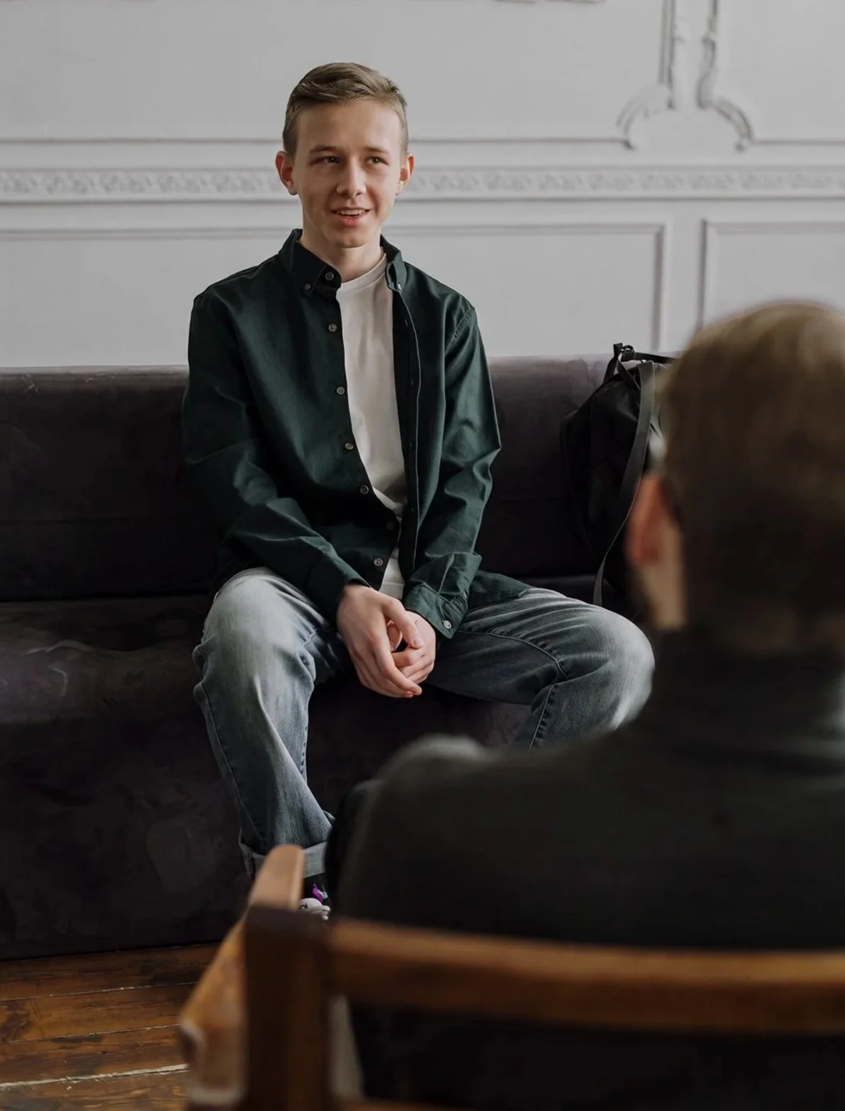 Young client sitting on a couch during a consultation meeting