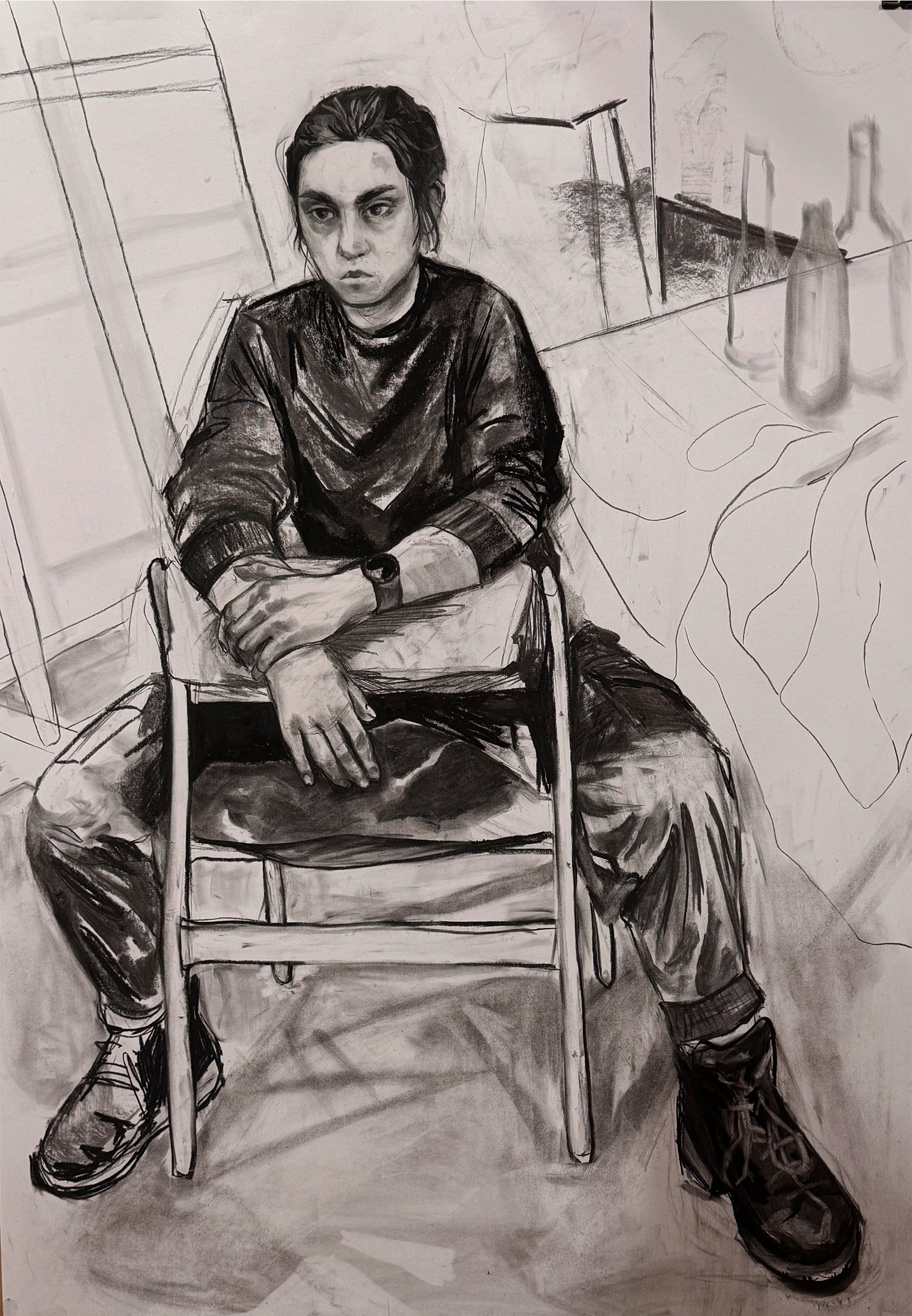A black and white drawing of a young person sitting on a chair. They have dark, messy hair, and a serious expression. They are wearing a dark sweater and pants, with their arms resting on their lap. The background features a window, some bottles on a