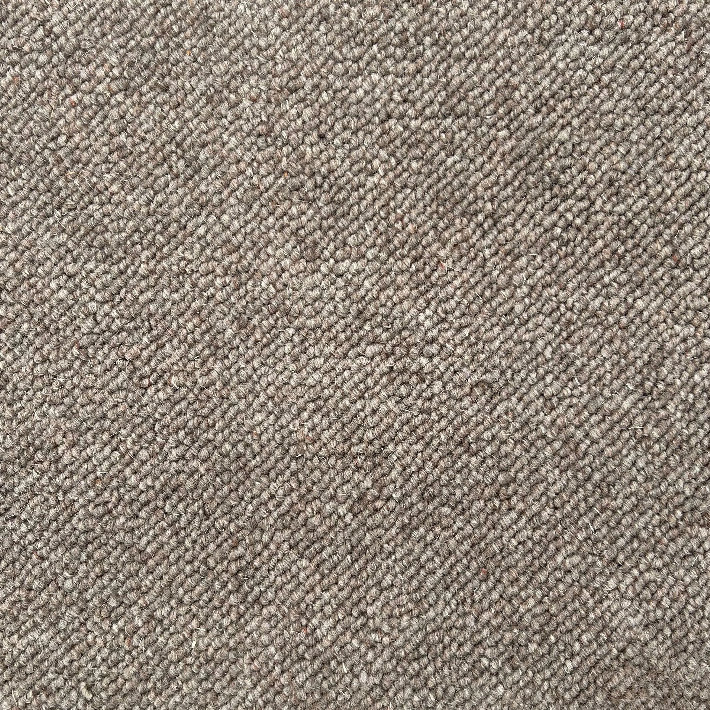 Close-up of a textured, brown, looped carpet.