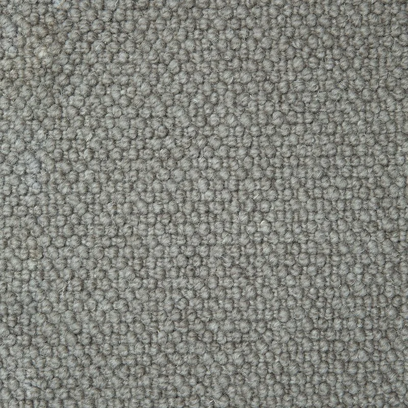 Close-up of beige carpet with tightly woven loops.