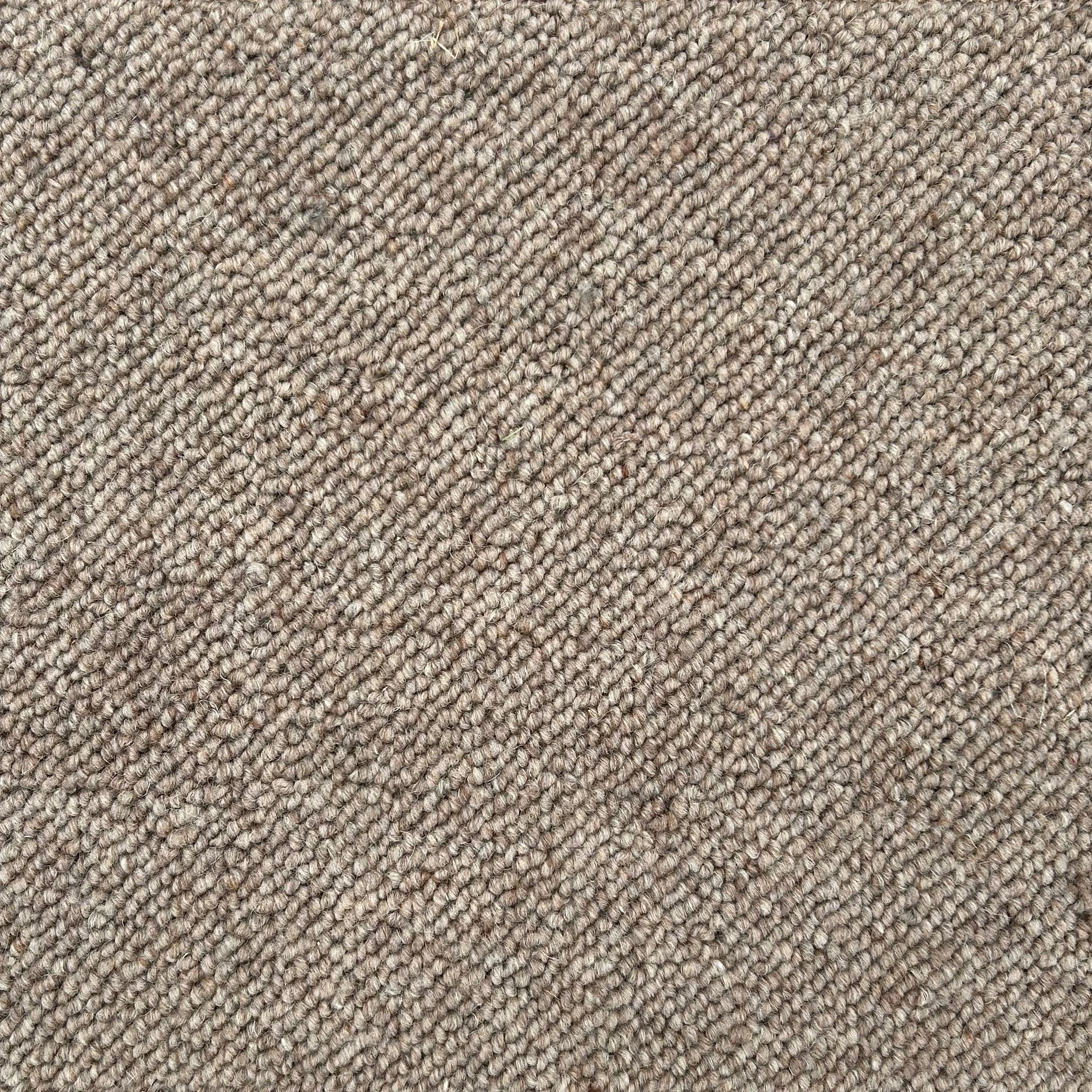 Close-up of beige and brown textured carpet with tightly woven fibers.