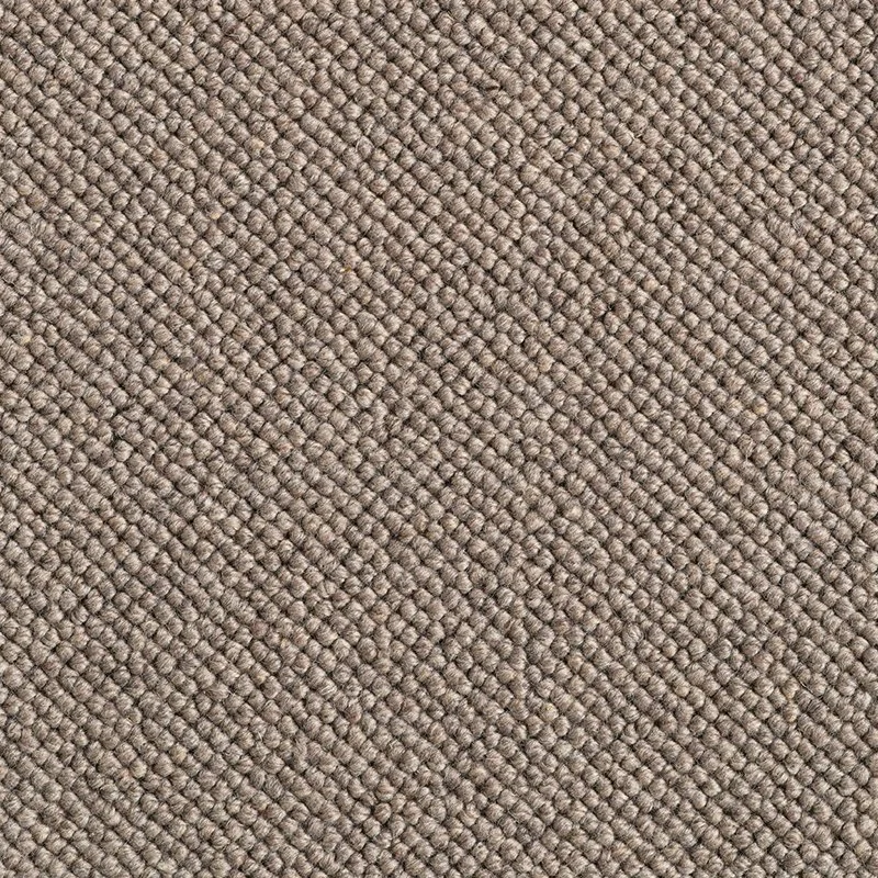 Close-up of a textured, beige carpet with a loop pile weave.