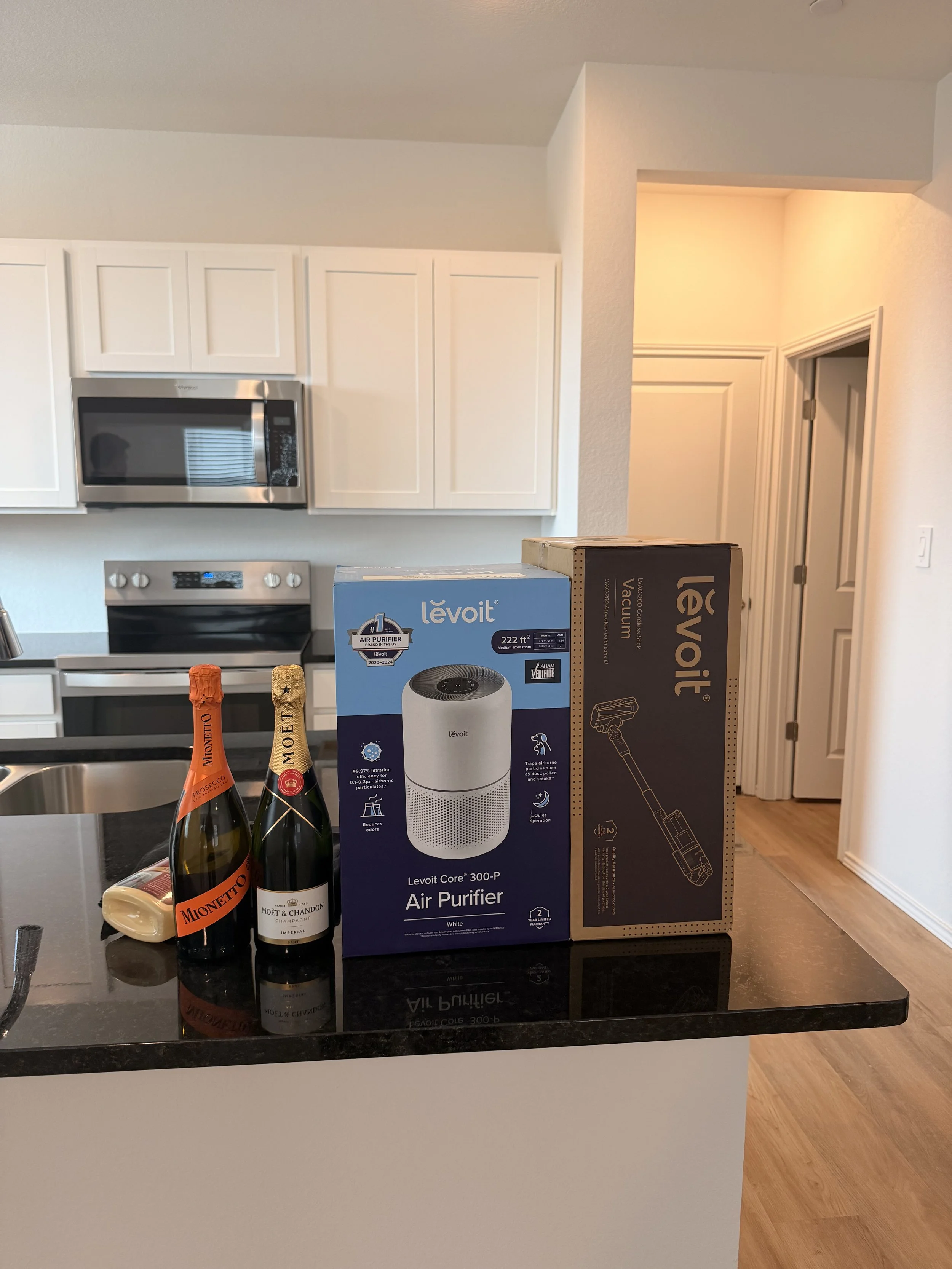 Housewarming gifts and champagne in the kitchen of a first-time buyer's new Austin home