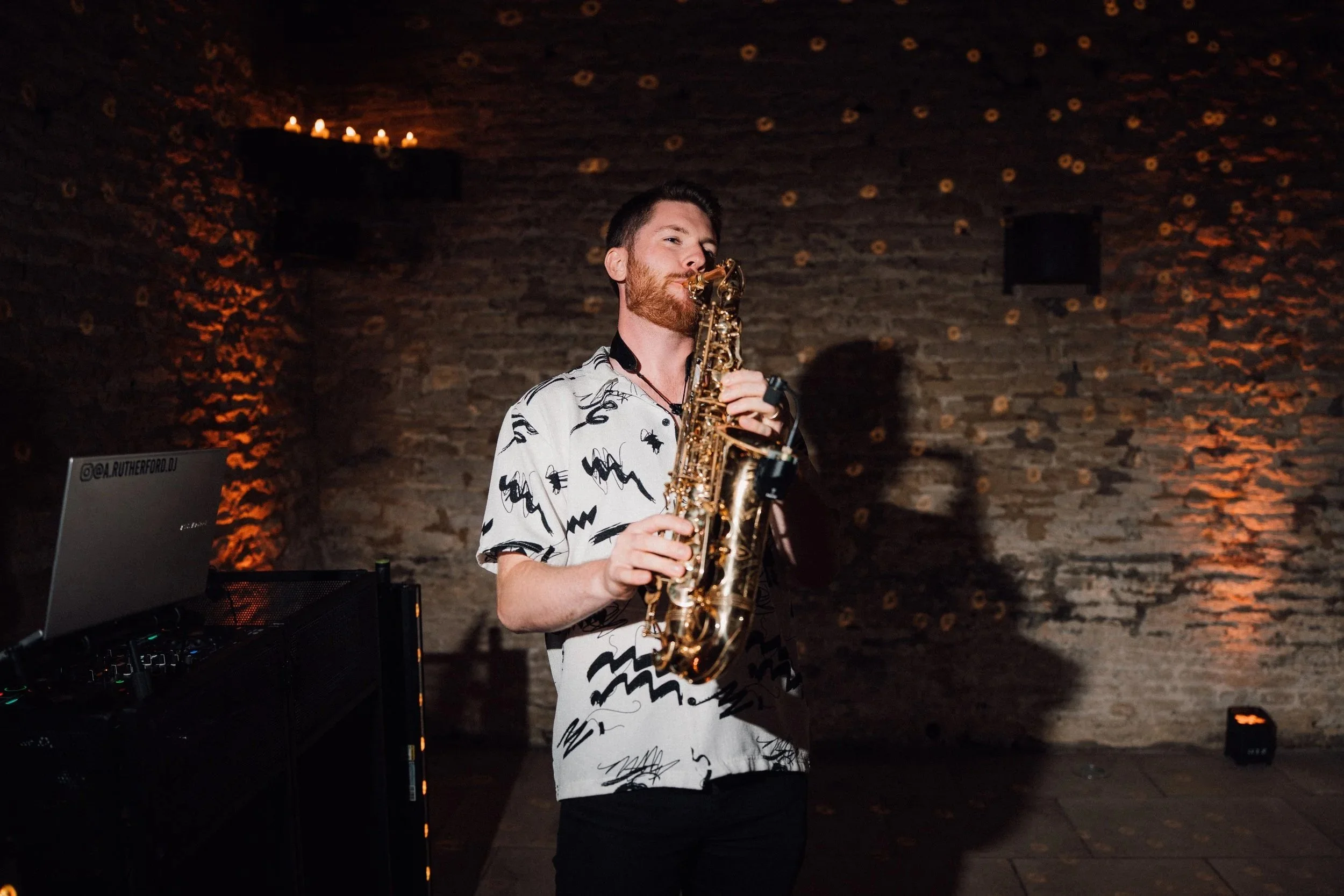 A saxophonist playing at a wedding in the cotswolds, old gore barn