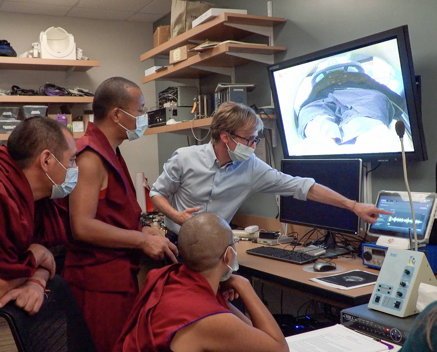 Medical team in masks reviewing an endoscopic procedure on computer monitors in a hospital room