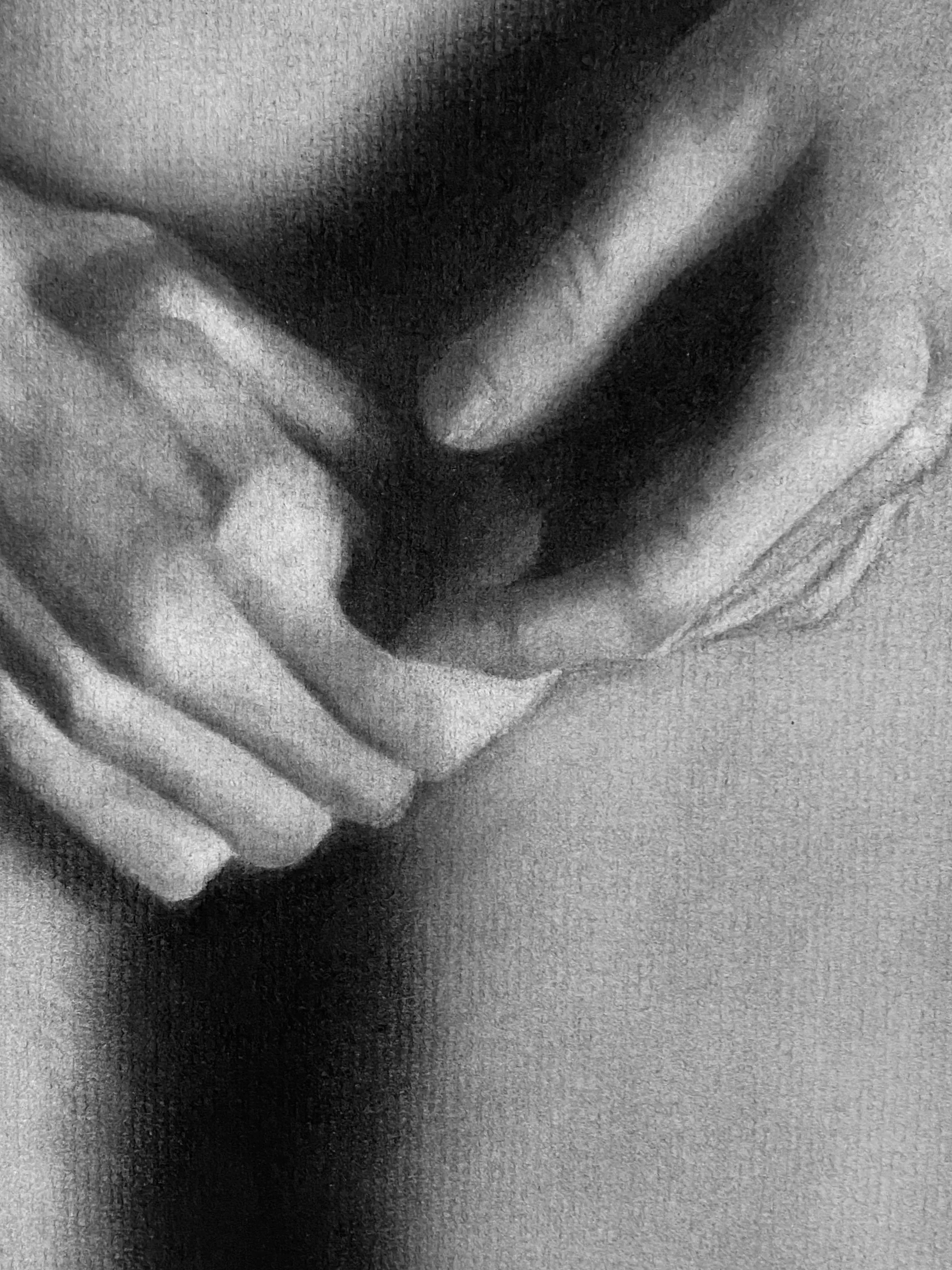 Close-up of two hands clasped together, one hand resting on top of the other, captured in black and white.