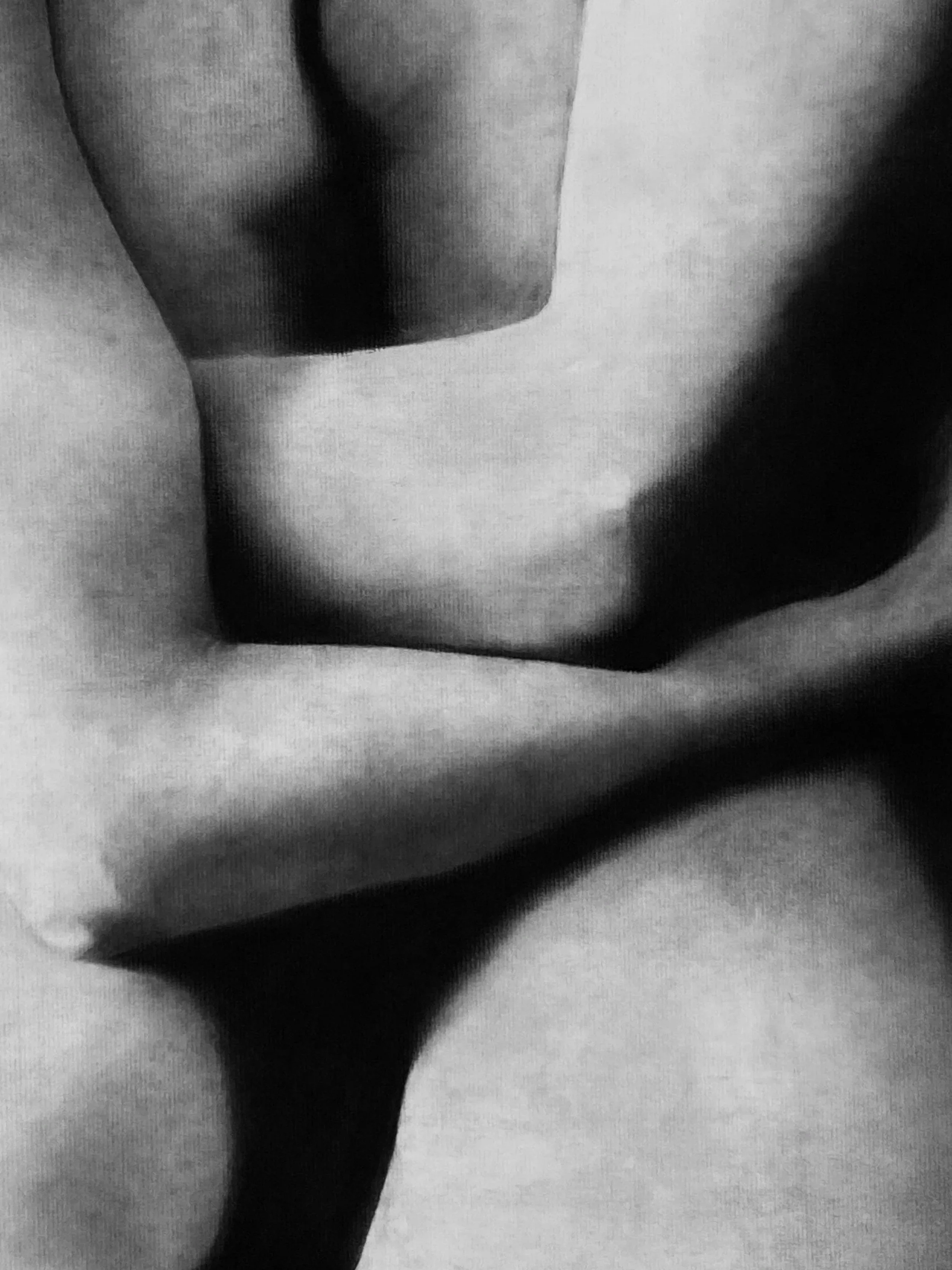 Close-up black-and-white charcoal drawing of two queer people entangled.