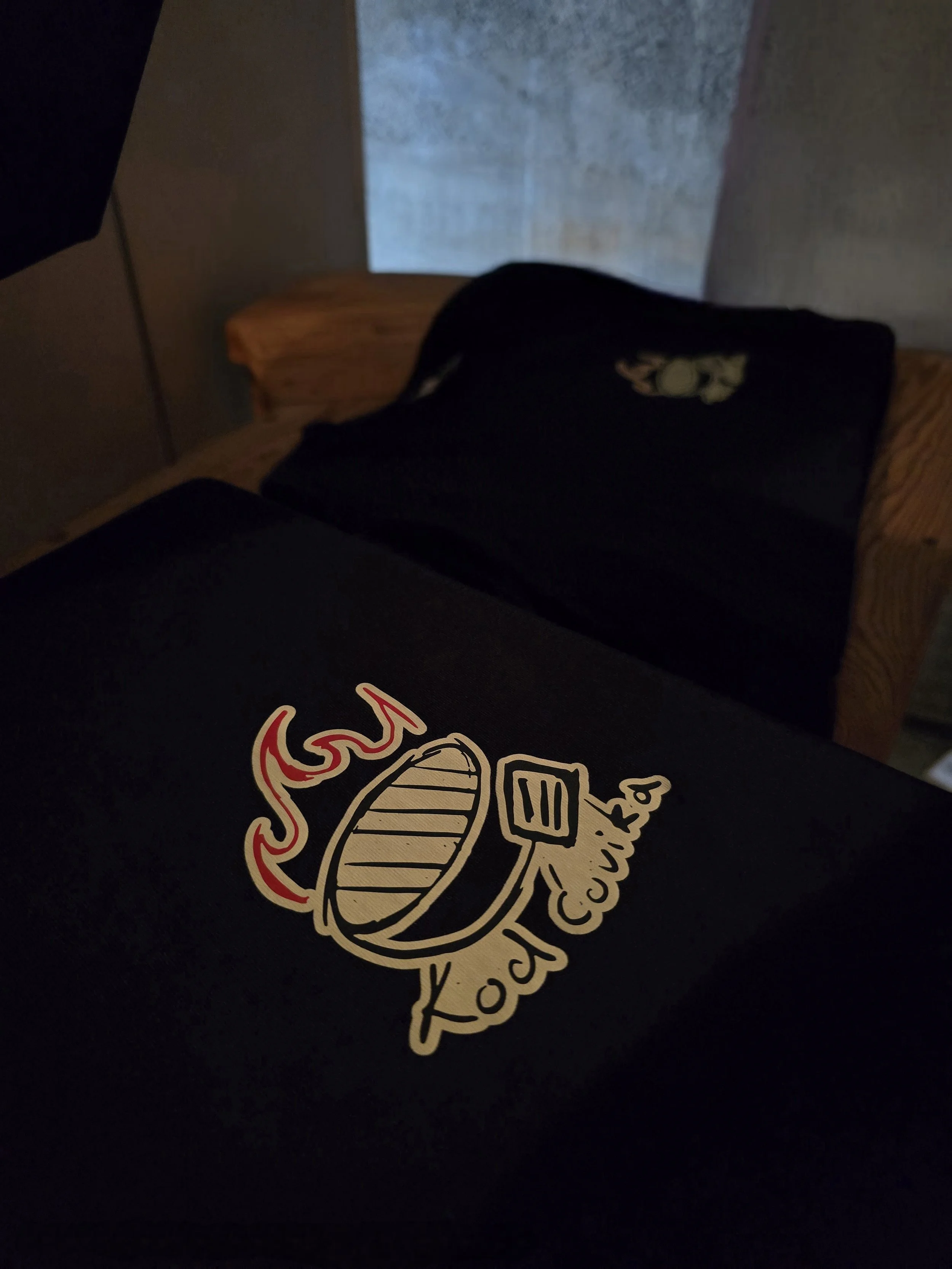 Close-up of a black t-shirt featuring a taco with the word 'tacos' in stylized text.