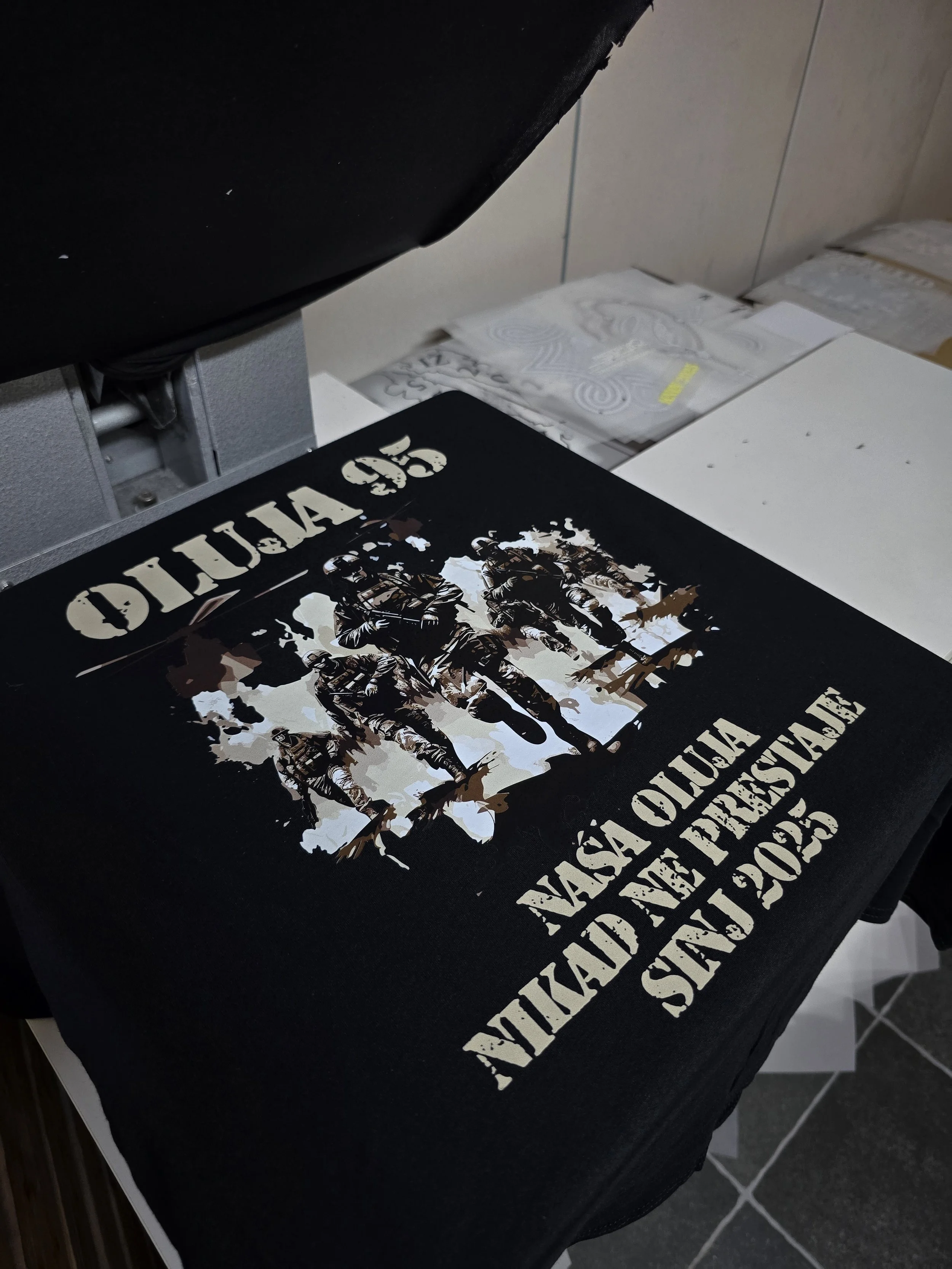A black tablecloth with white text that reads 'VASA CAUISTIC' and an image of soldiers in military gear.