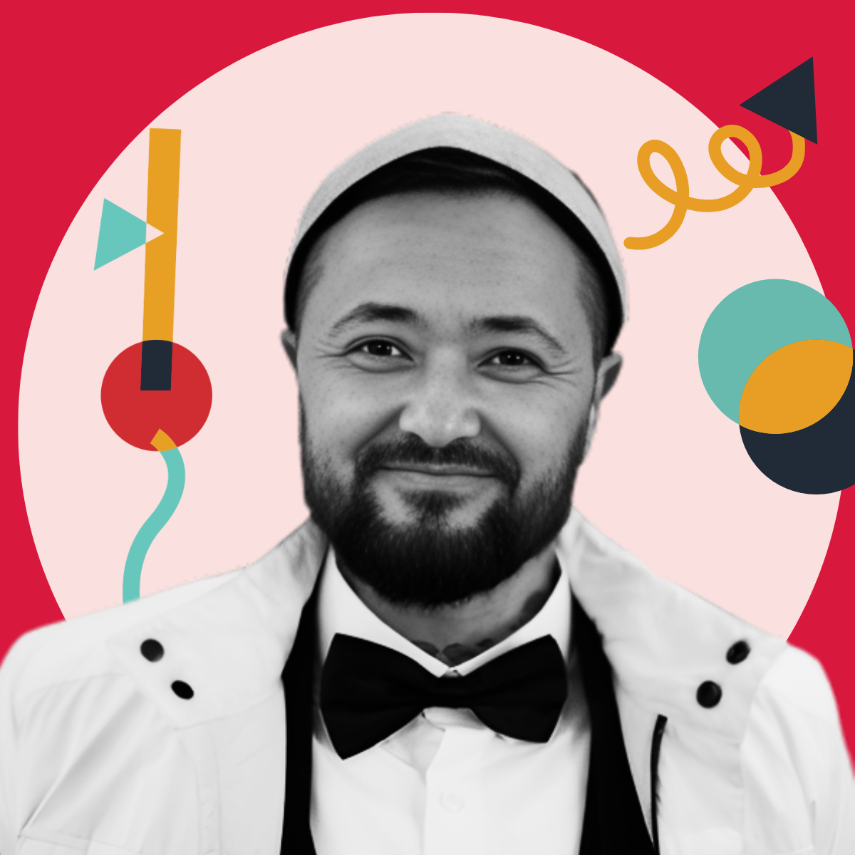 A smiling man with a beard and mustache in formal attire, wearing a tuxedo and bow tie, with a white headband, against a colorful abstract background.
