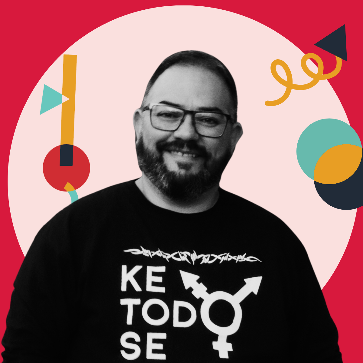 A man with glasses and a beard smiling, wearing a black sweatshirt with a gender symbol and the words "Keep Today Safe," in front of a pink background with colorful abstract shapes.