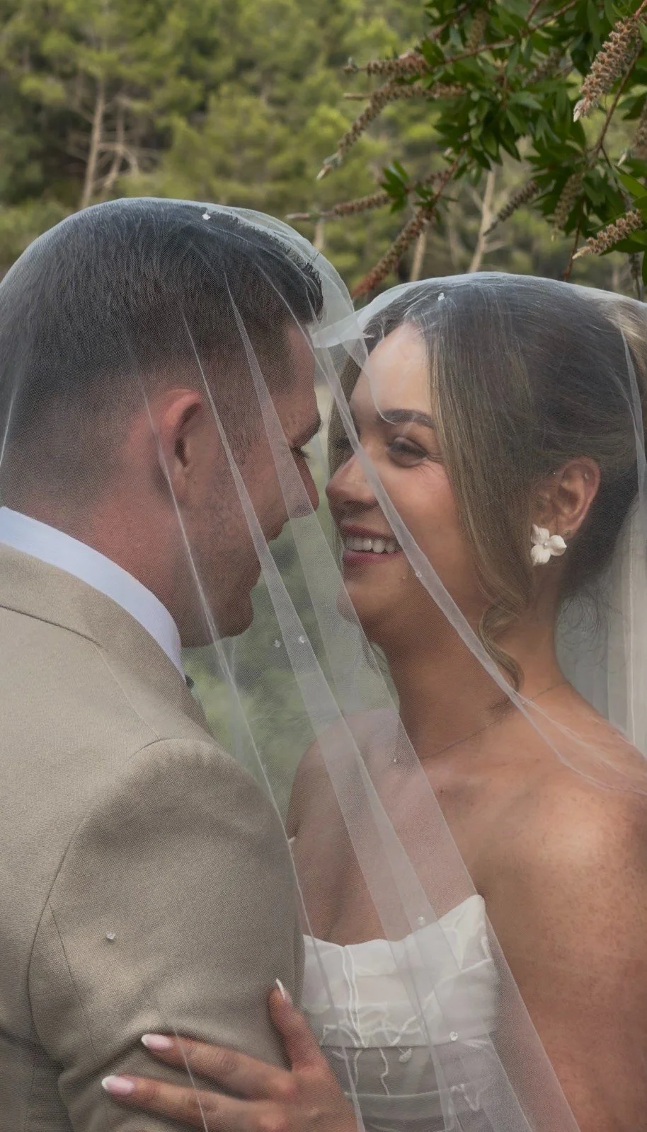 Happy couple laughing under veil