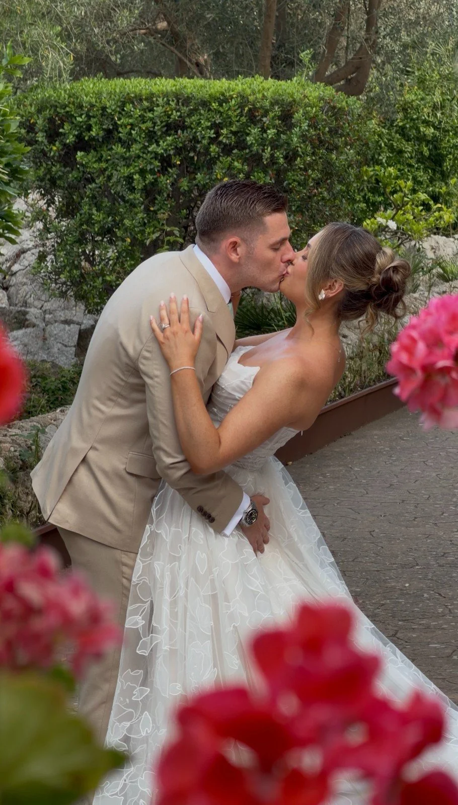Kissing married couple, framed by flowers