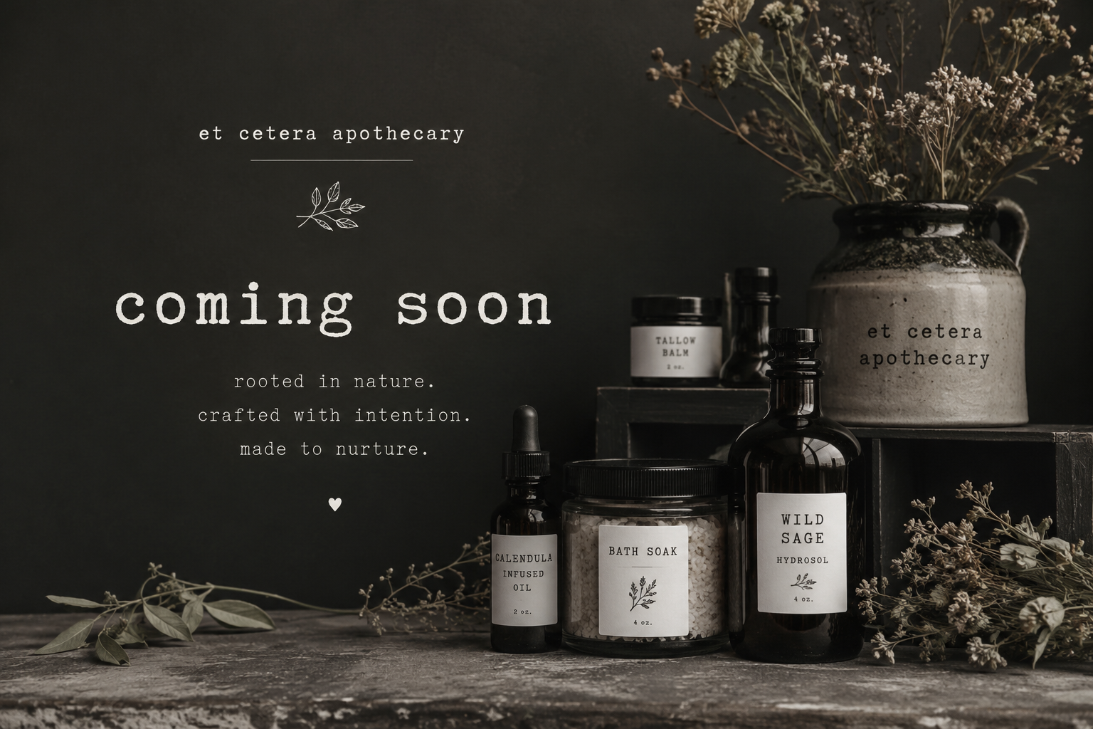A dark rustic display of herbal wellness products including bottles labeled 'Calandula infused oil', 'Bath soak', 'Wild sage hydrosol', and 'Tallow balm'. There is a large ceramic vase with dried flowers behind the bottles, and the background features a dark wall with the words 'coming soon' and a message about nature-inspired, intentional products.