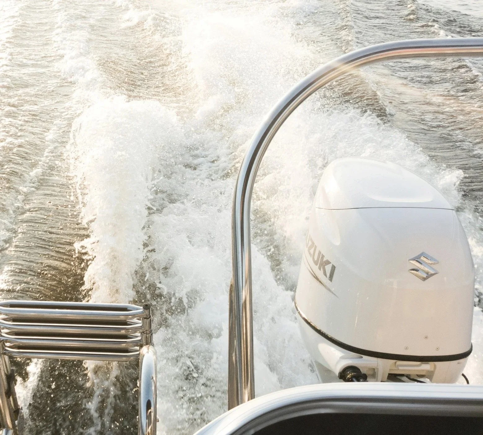 View from a boat showing a Suzuki outboard motor and water splashing behind as the boat moves forward.