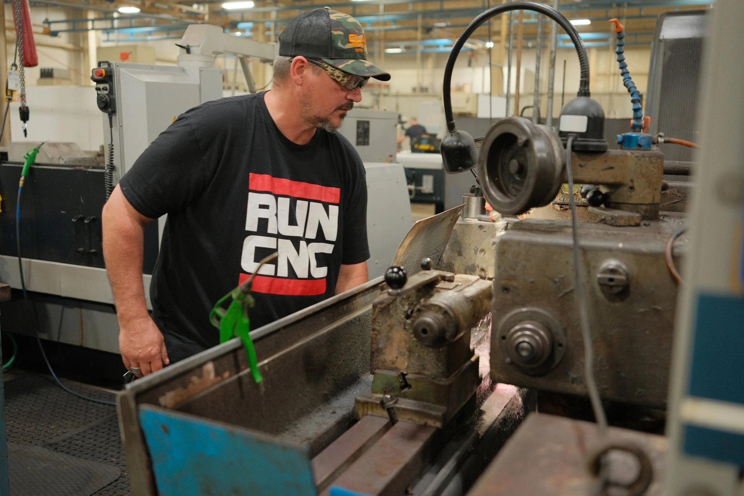 Machinist operating a lathe for precision CNC machining at Clark Manufacturing