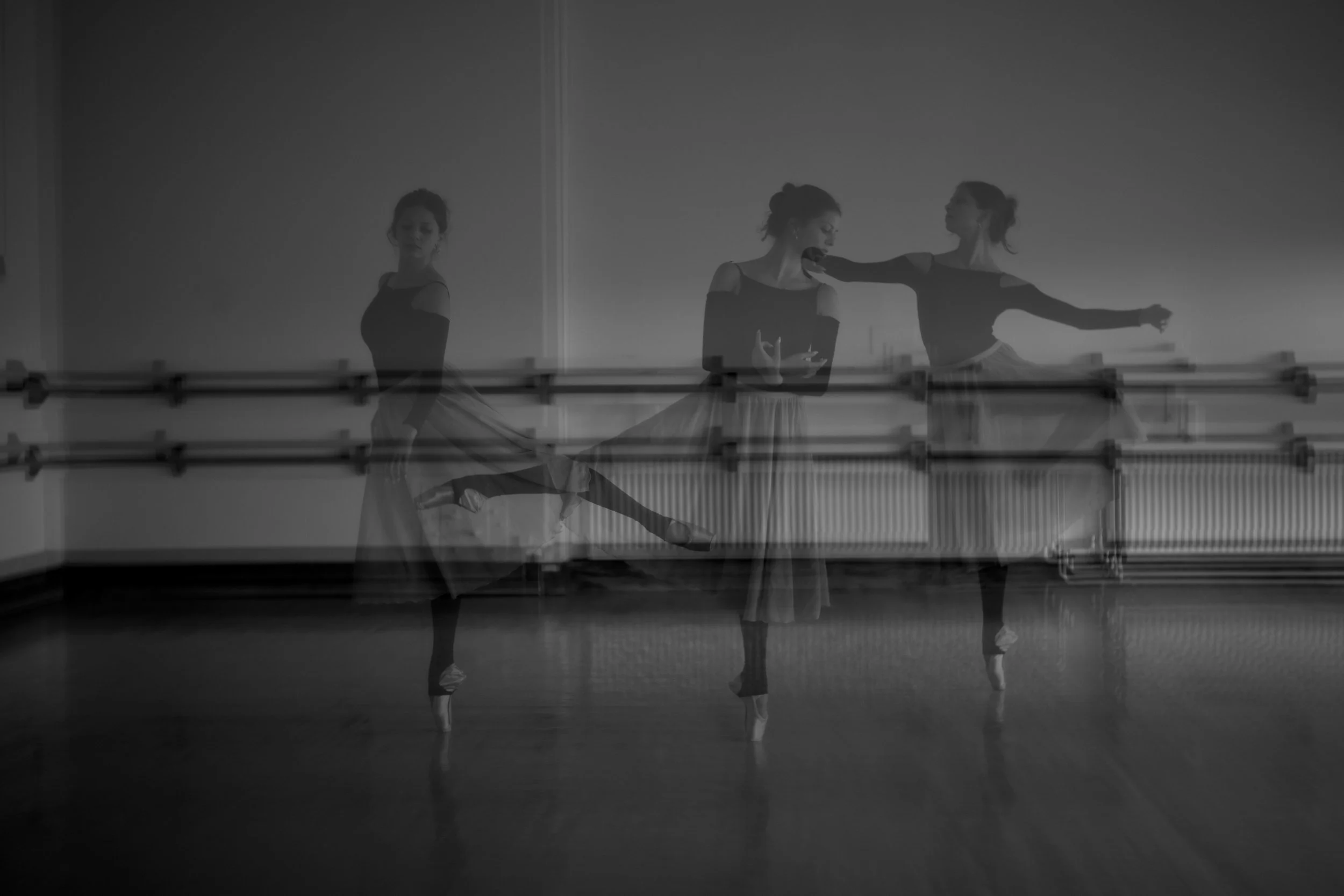 A black and white photo of a ballerina practicing in a dance studio, with multiple exposures showing different poses, including a standing pose, a pose with arms extended, and a pose with one leg lifted.