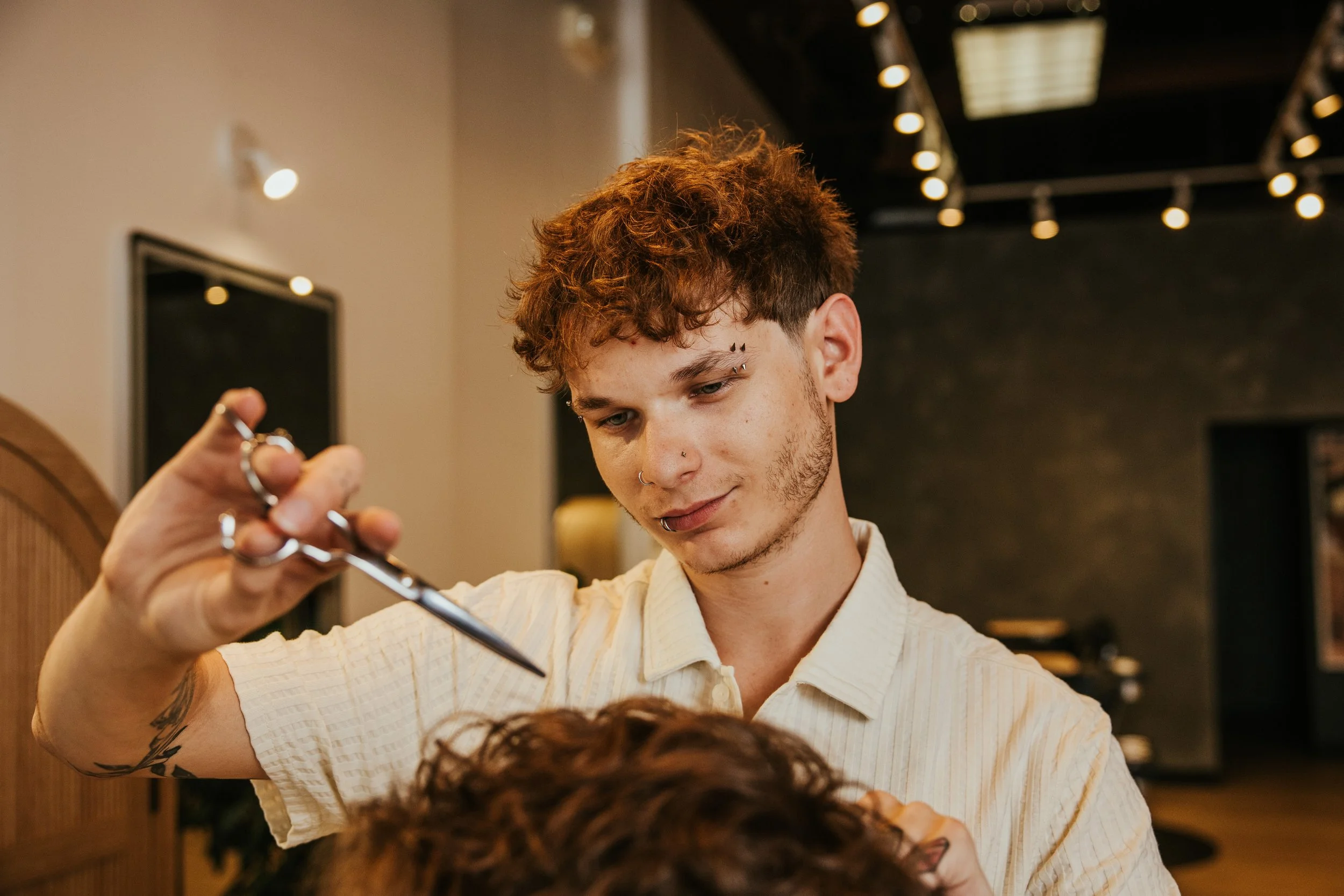 a young barber using strong scissor work on a textured haircut
