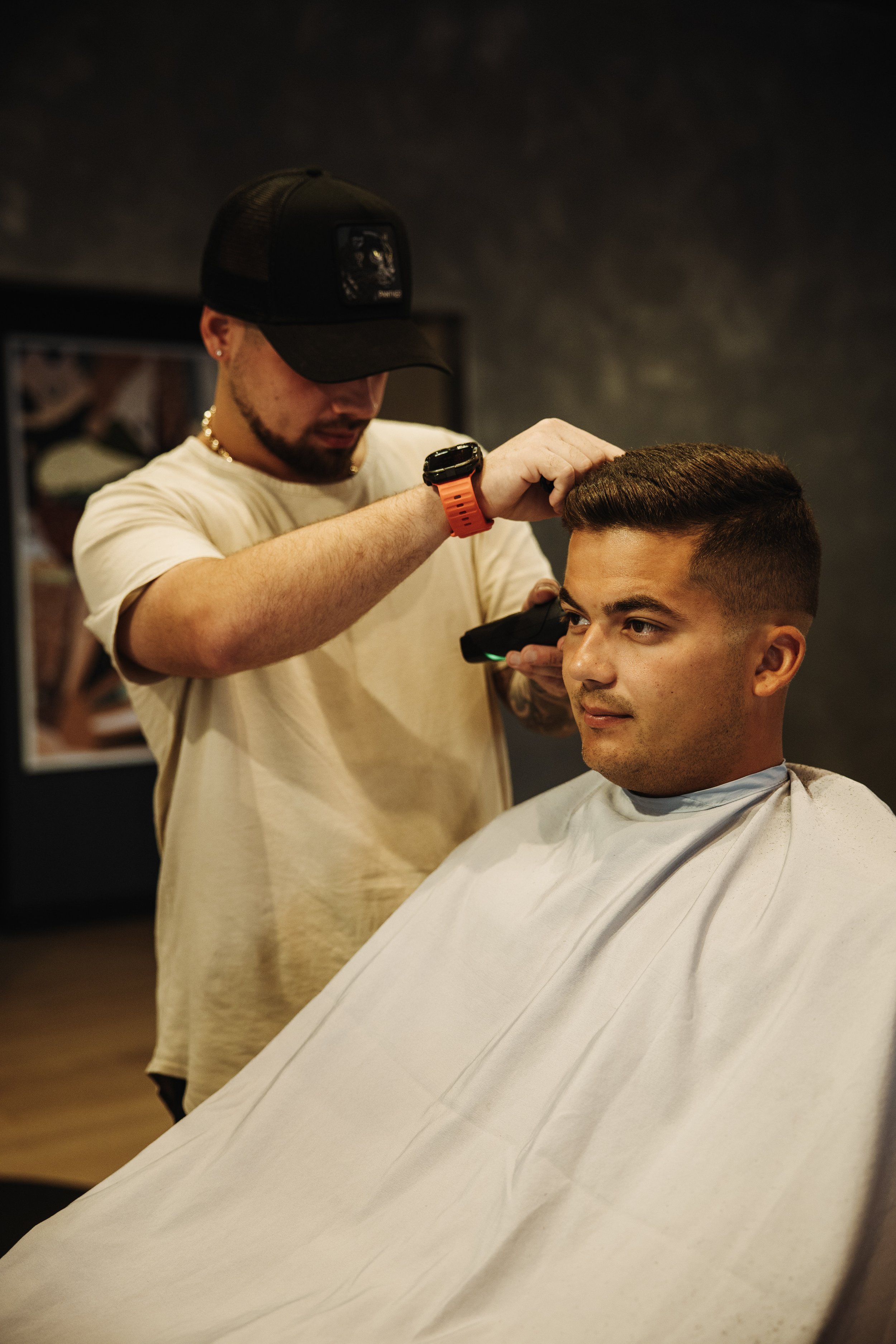 Barber using clippers to perform a fade into a crew cut