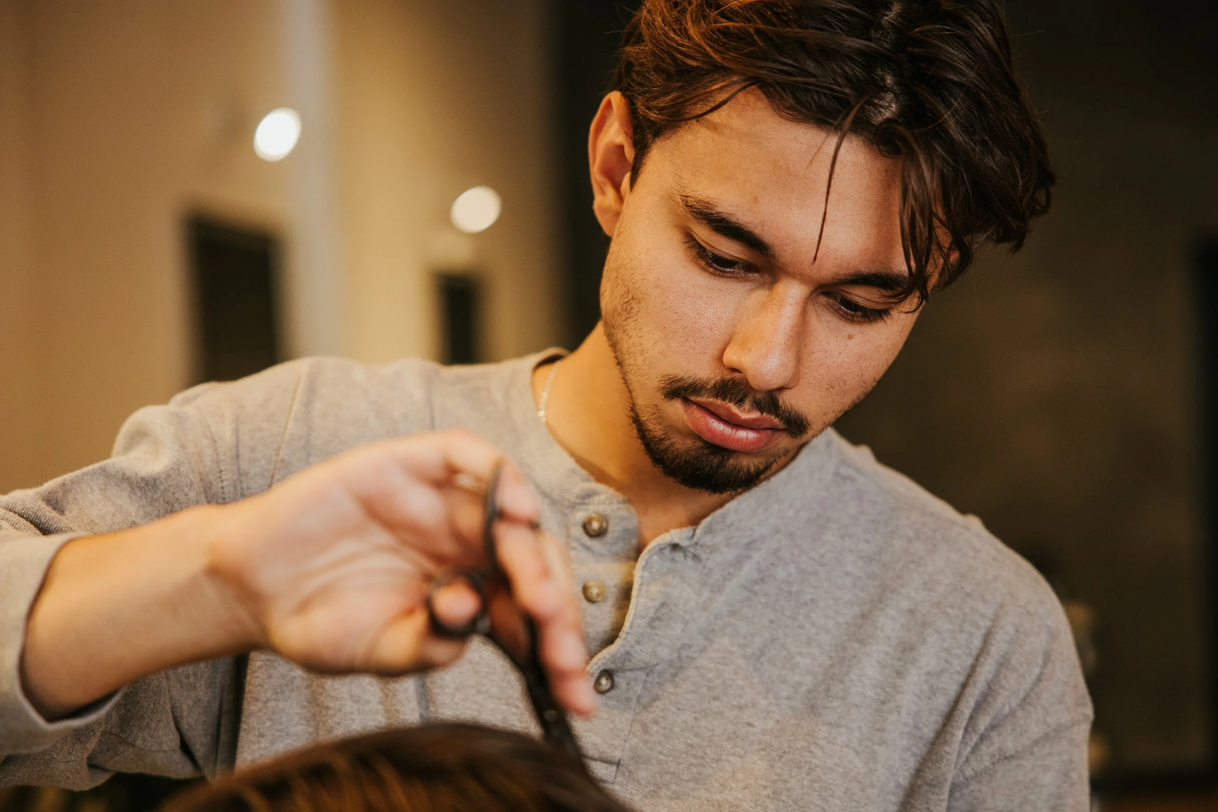 barber focuses intently on blending fade lines