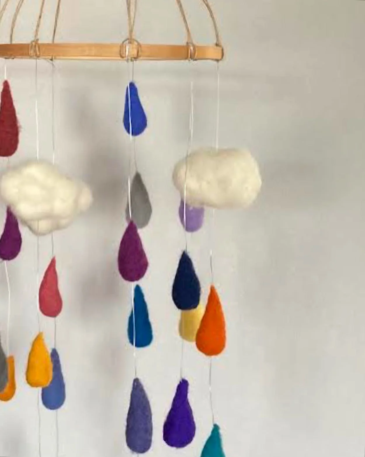 Colorful felted wool cloud and raindrop hanging mobile decoration.