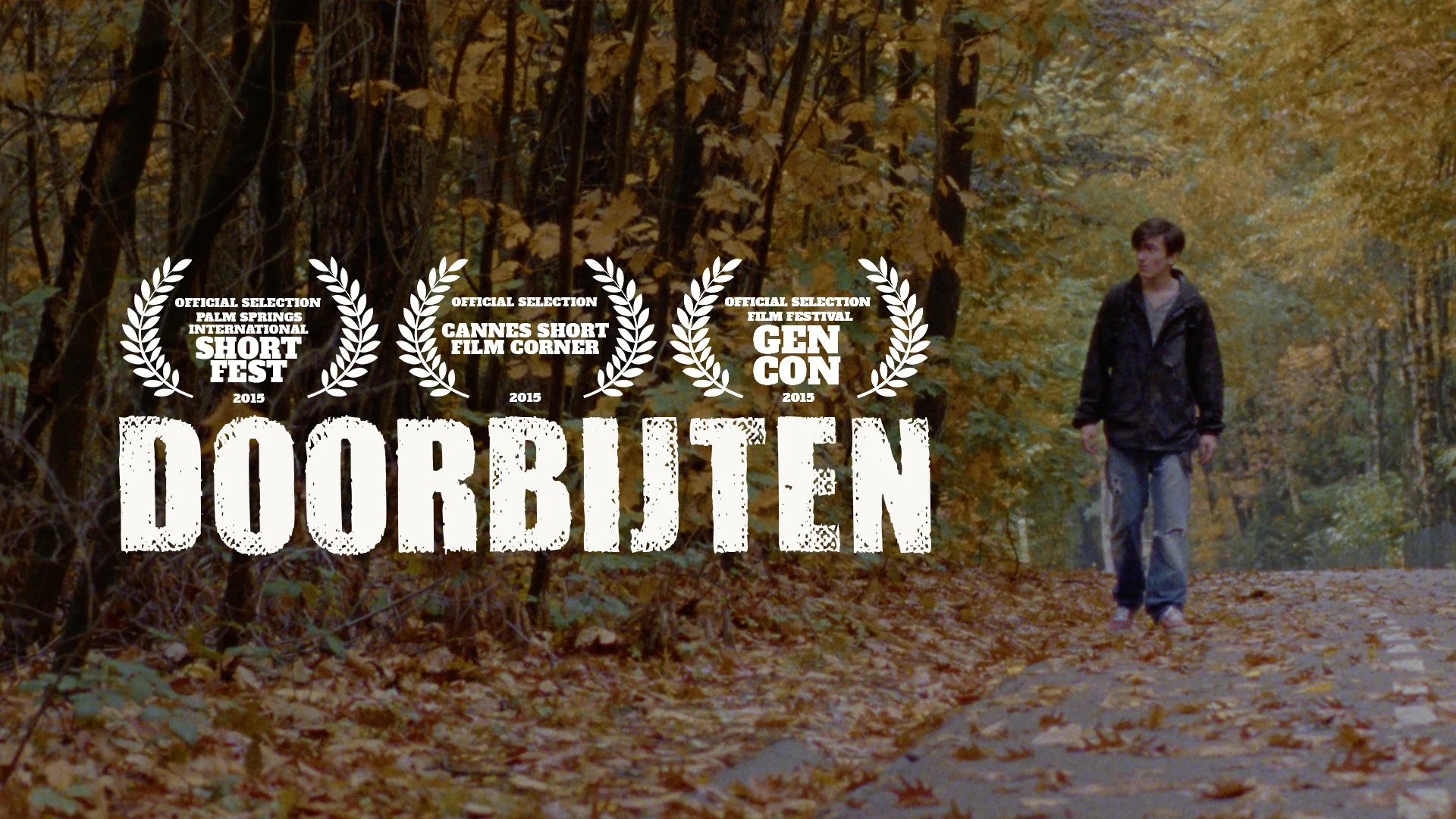A young man walking through an autumn forest with fallen leaves, with multiple film festival laurels and the title of the short horror film "Doorbijten" overlaid.