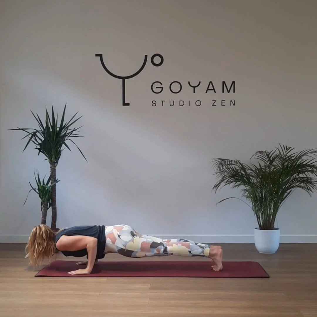 Laura en position de planche sur un tapis de yoga au studio GOYAM STUDIO ZEN
