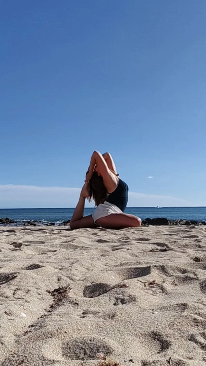 Femme en position de yoga sur la plage, sable, mer et ciel bleu en arrière-plan.