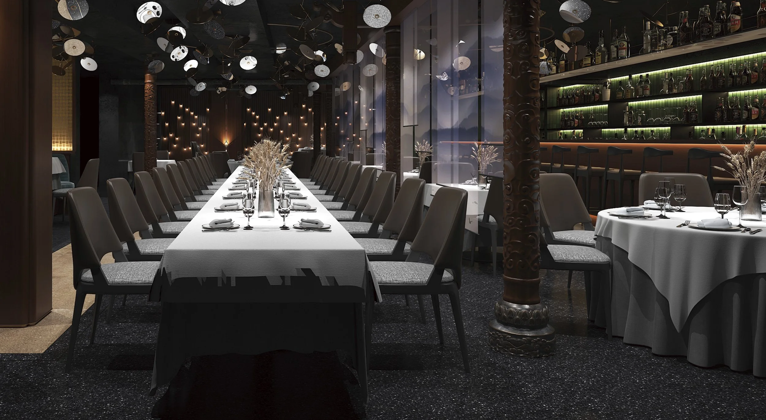 Elegant restaurant dining area with a long table set with white tablecloths, wine glasses, and silverware, surrounded by gray chairs. The background features a bar with shelves of liquor bottles, decorative hanging light fixtures, and large windows showing a scenic mountain view.