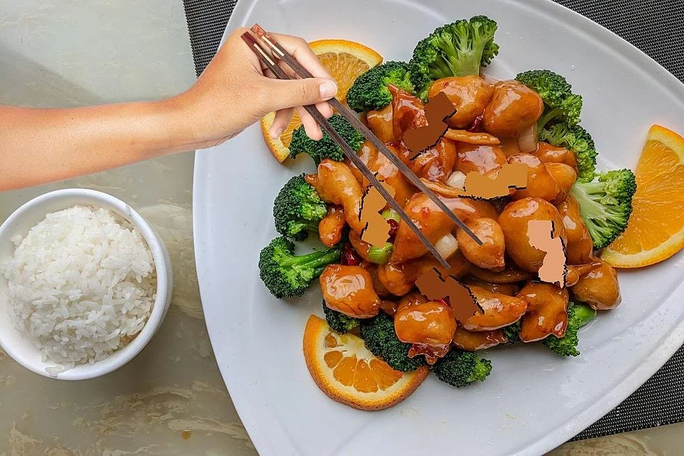 A dinner plate with broccoli and orange slices, topped with orange chicken, and a bowl of white rice