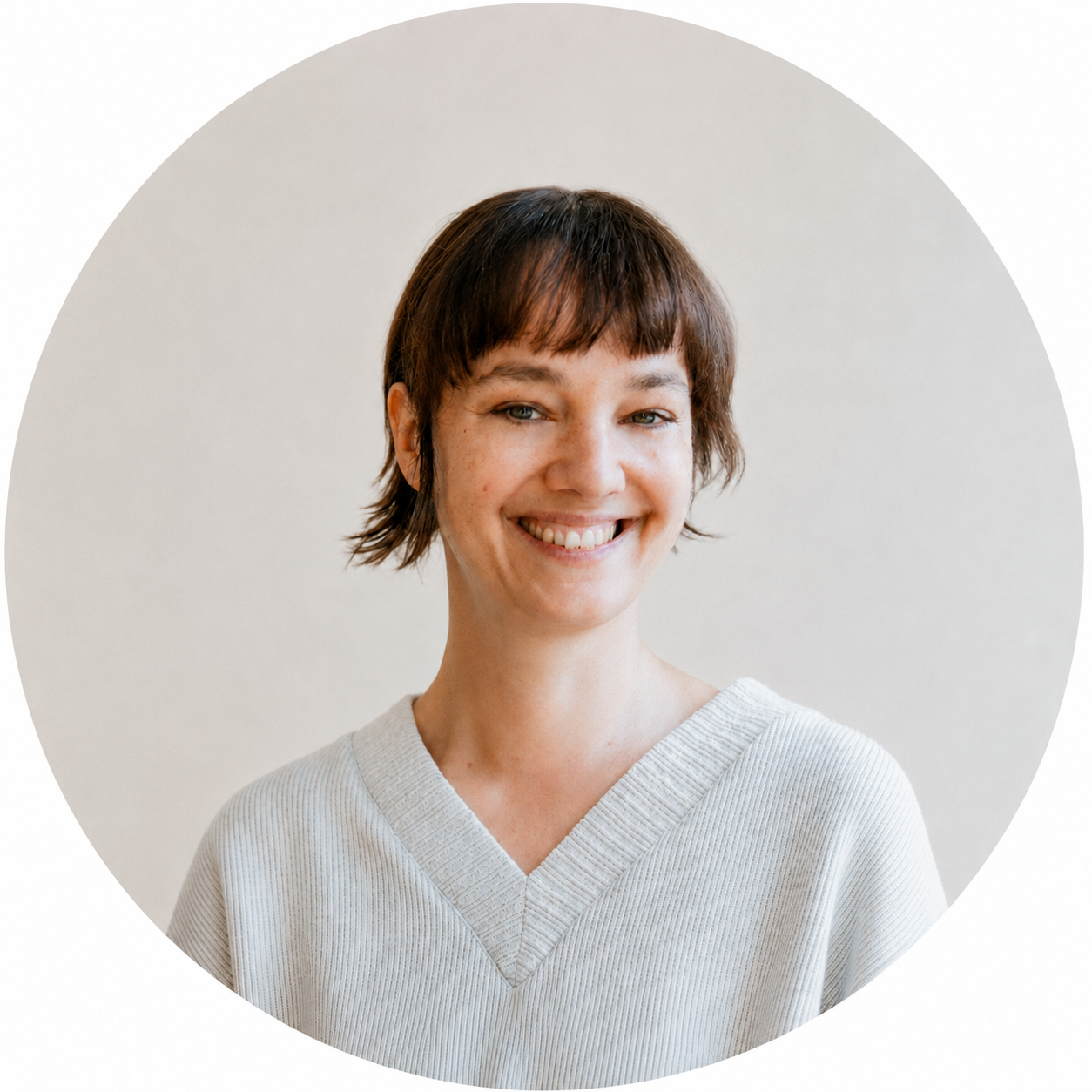 Porträt von Dr. Taiya Mikisch mit braunen Haaren, die zu einem Zopf zurückgebunden sind. Sie trägt einen weißen Pullover. Der Hintergrund ist neutral.