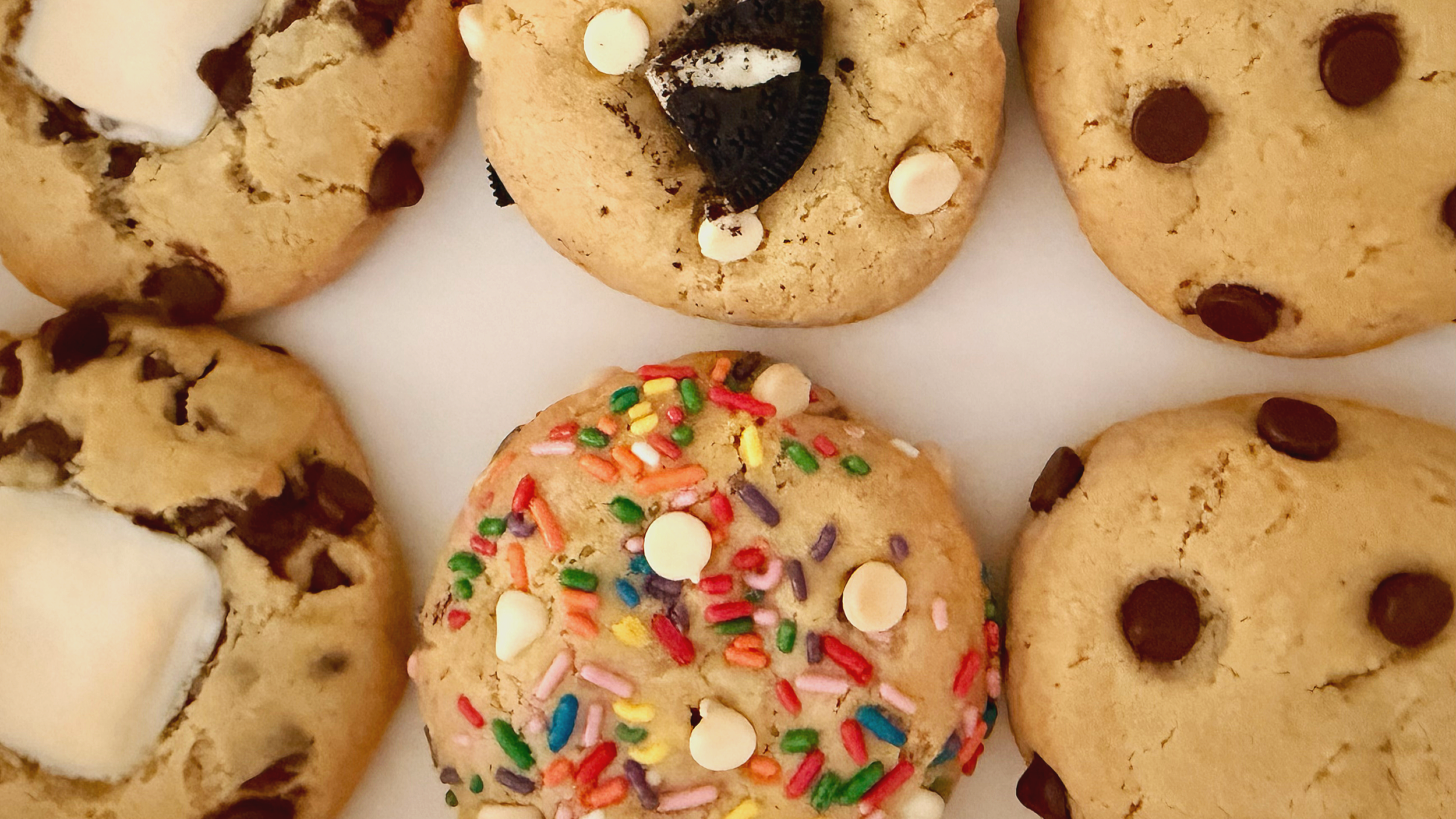 Assorted cookies decorated with chocolate chips, sprinkles, and white chocolate chips.
