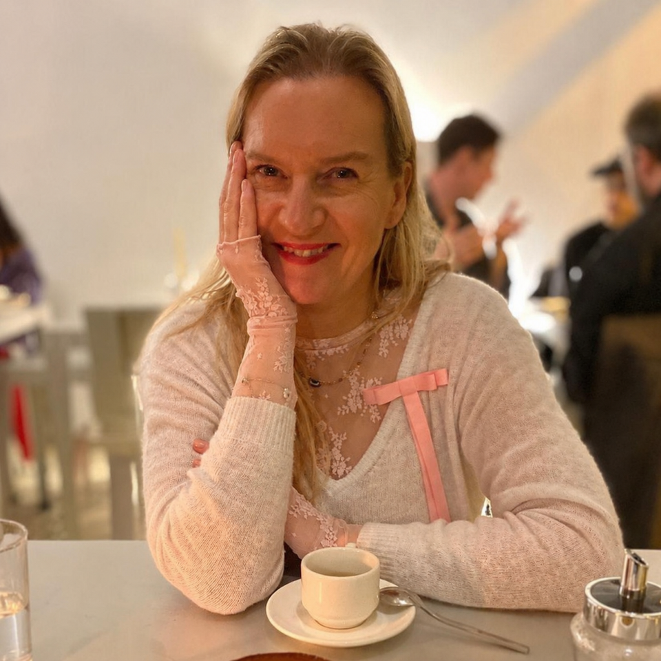 Jo Brooks, co-founder of Art MOT, smiling at a café table.