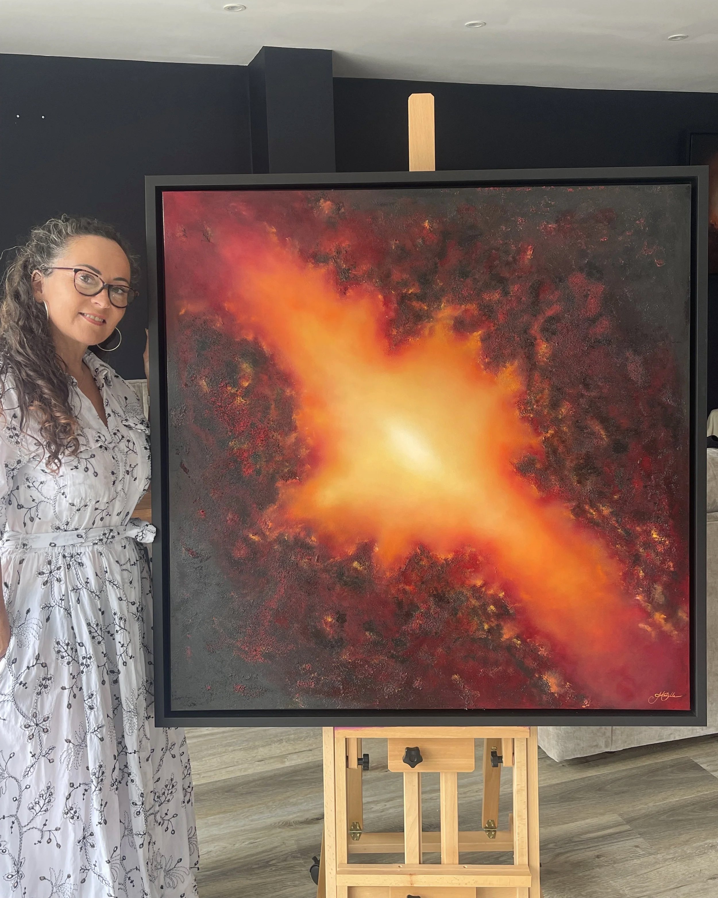 Artist Mechelle Tebbs standing beside her expressive abstract oil painting, Unbound.
