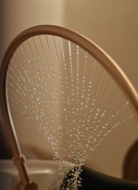 A mirror with several water droplets on its surface.