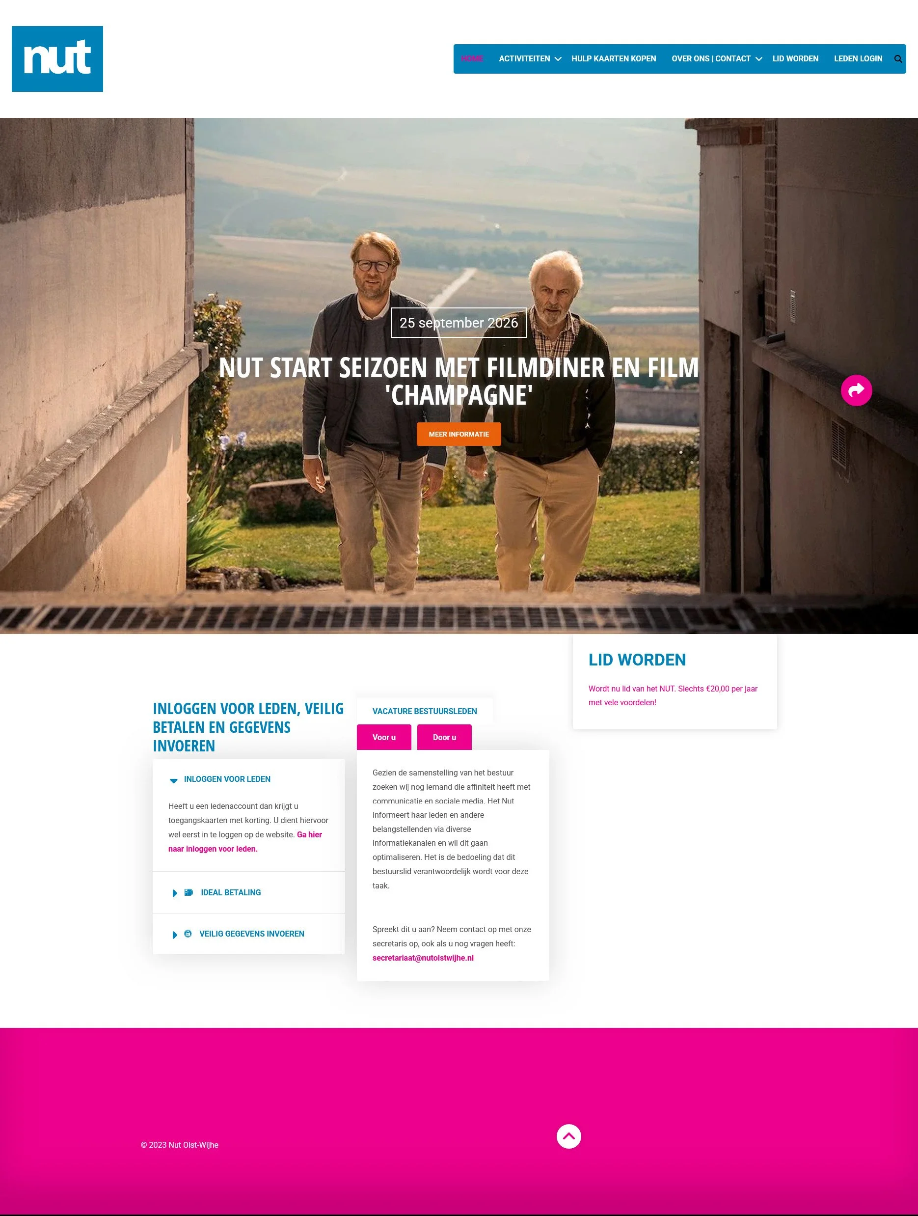 De website van Nut Olst-Wijhe met een foto van twee mannen die buiten lopen met een landschap op de achtergrond, en een roze en blauwe kleurstelling op de site.