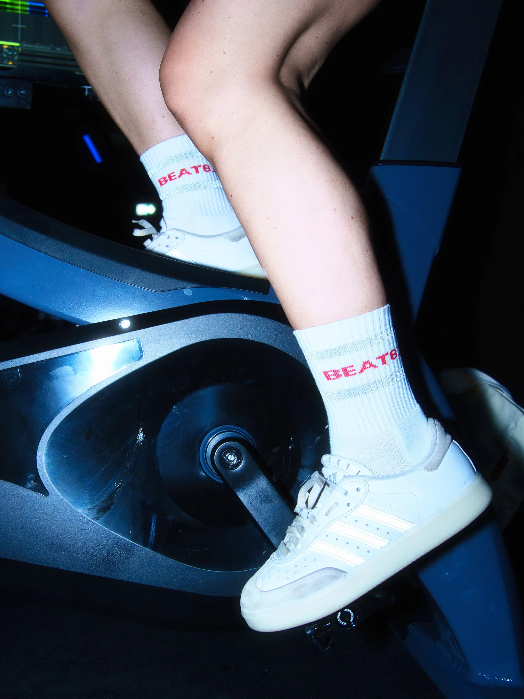 Nahaufnahme eines weißen Sneakers mit weißen Socke, mit roter Schrift 'BEAT'