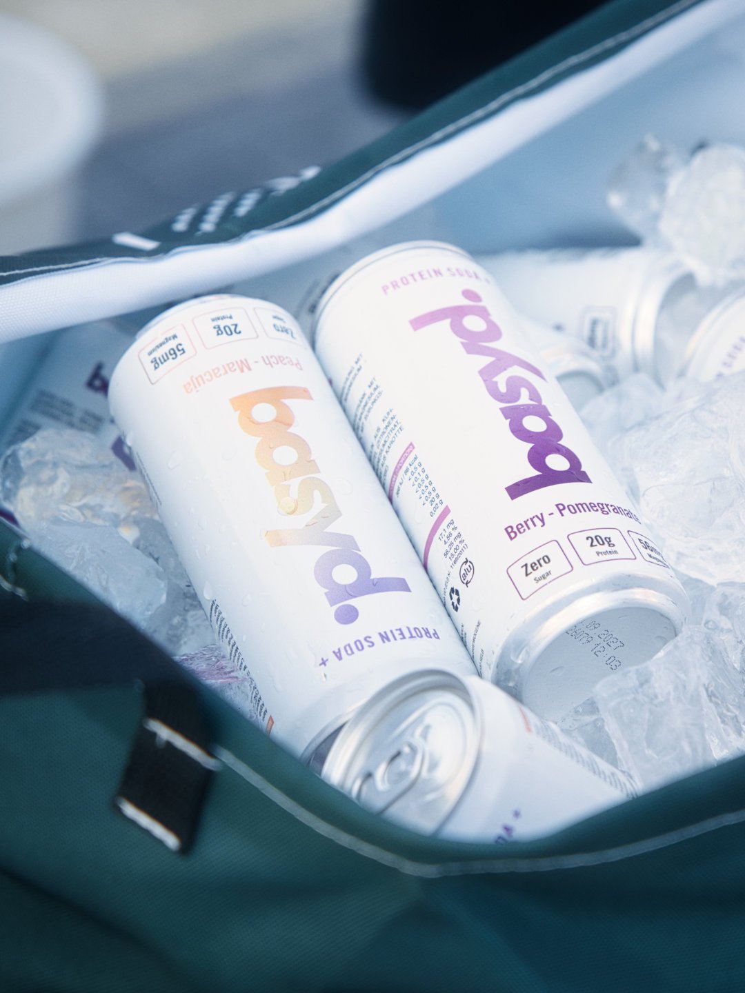 Dosen mit Protein-Getränken in einem eisgefüllten Behälter, die Marke ist Boost, Geschmack Himbeere-Grenadine