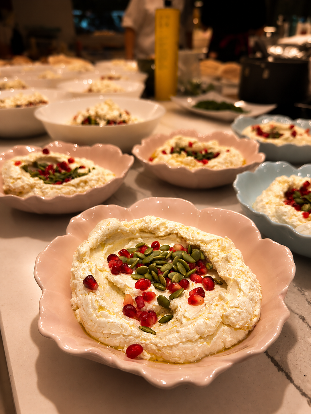Creamy labneh topped with pomegranate seeds and served as part of a Mediterranean sharing feast.