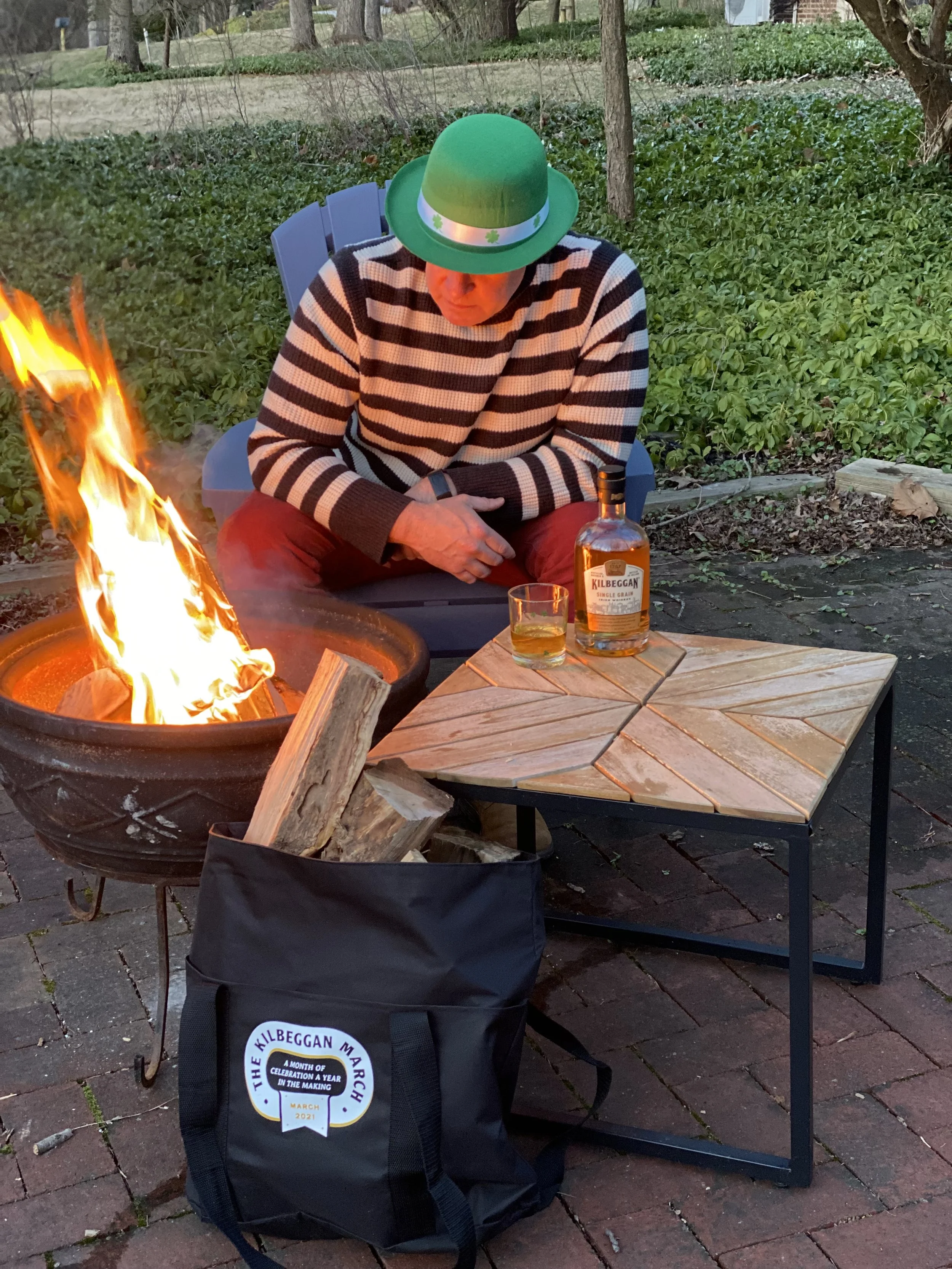 Mark Makers sitting by a fire drinking whiskey from his collection