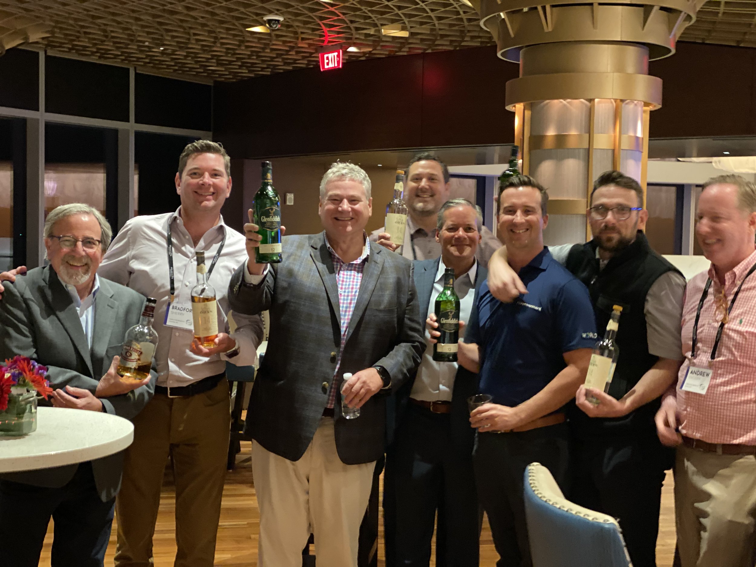 Members of the whiskey club smiling at an event