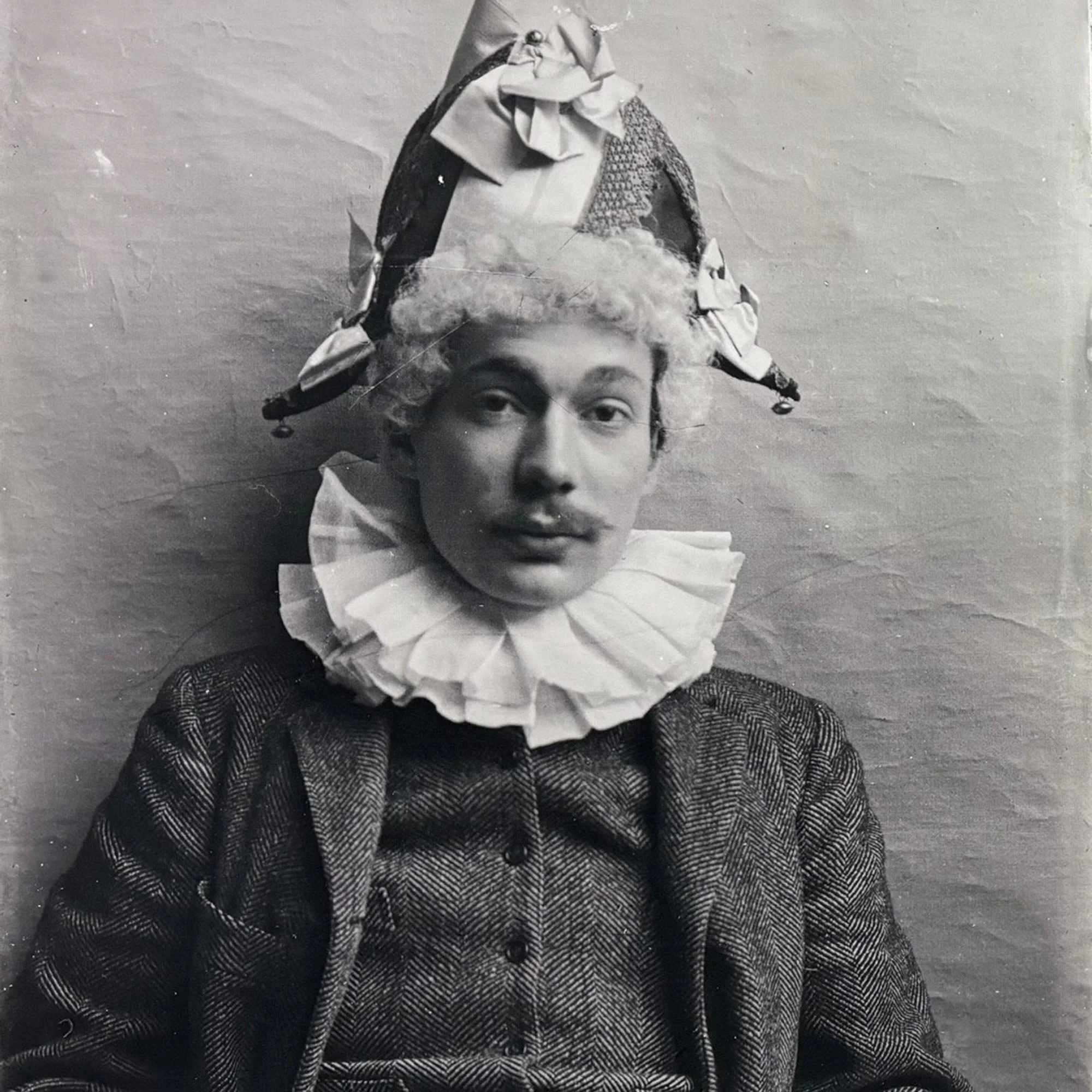 Black and white photograph of man wearing a clown hat, France, c. 1870-1915.