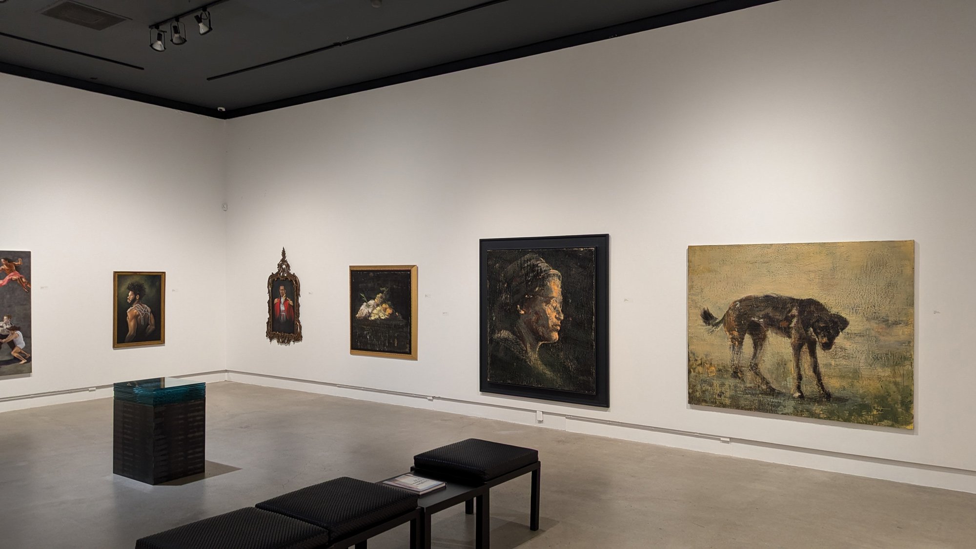 Paintings from a past exhibition at Gallery Stratford, including portraits of a woman and a dog in foreground.