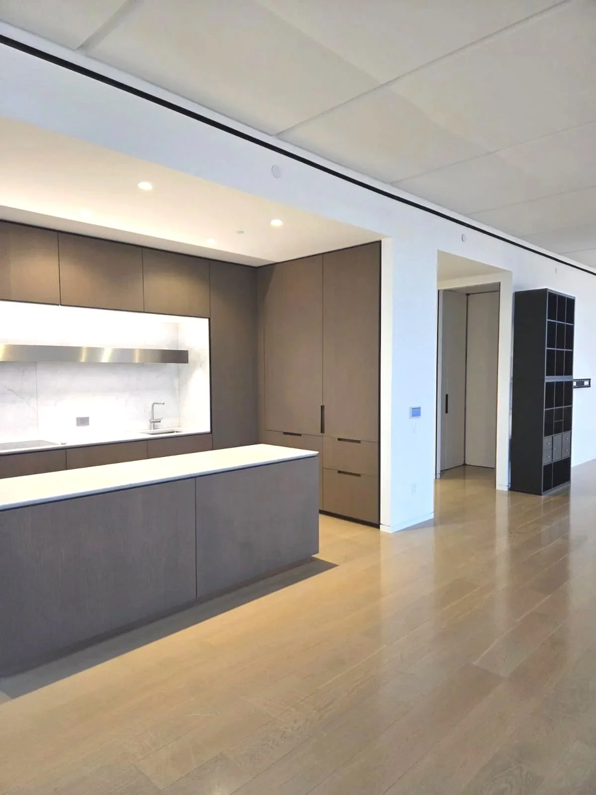 Clean modern kitchen with brown cabinetry and white countertops.