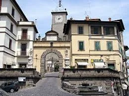 Vista di un'entrata medievale con torre e edificio storico in zona urbana