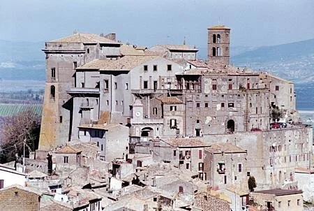 Vista di un antico complesso edilizio su una collina con un campanile in lontananza