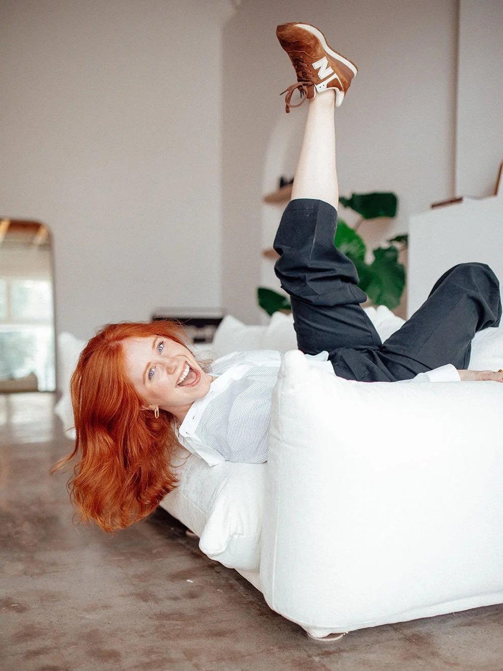 Haleigh Culverhouse smiling while reclining on a white couch.