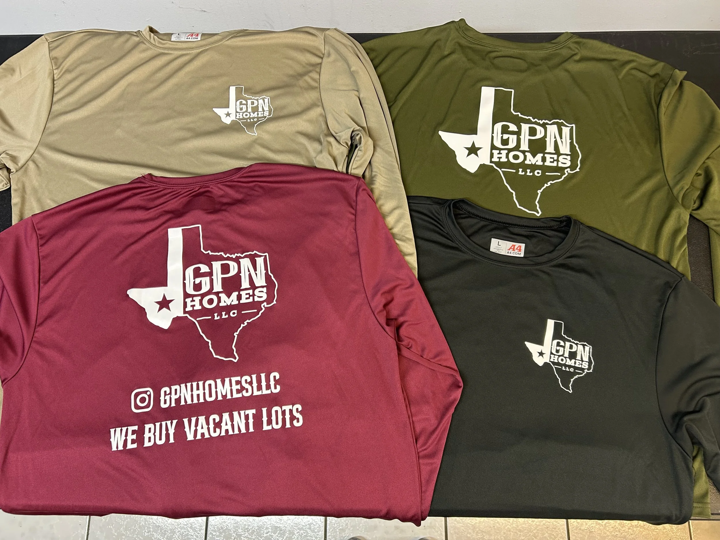 Four T-shirts with GPN Homes LLC logo, showing the outline of Texas with a star at the bottom left. The colors are tan, olive green, red, and black